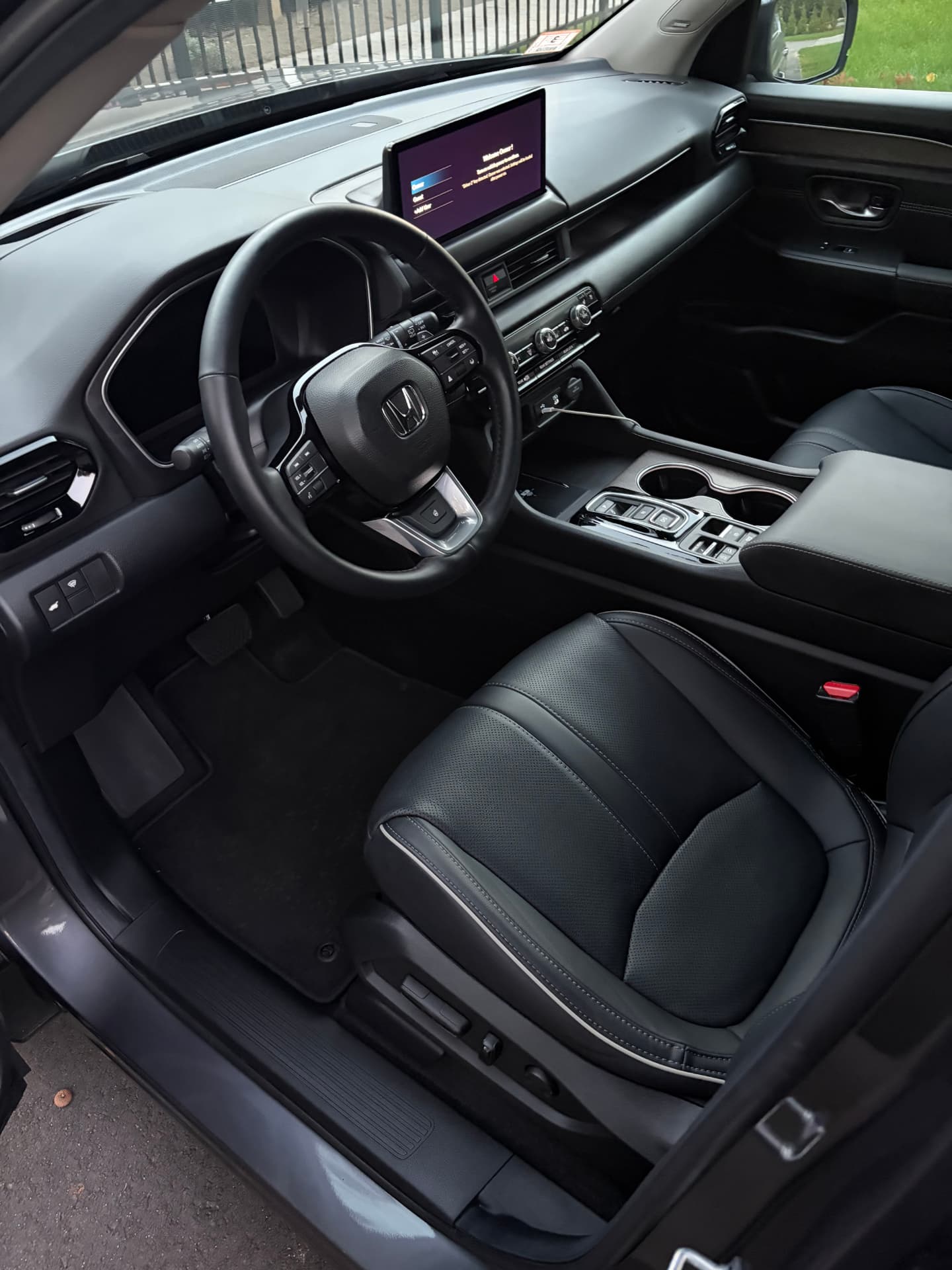 Detailed Honda interior with clean steering wheel, dash, and leather seat